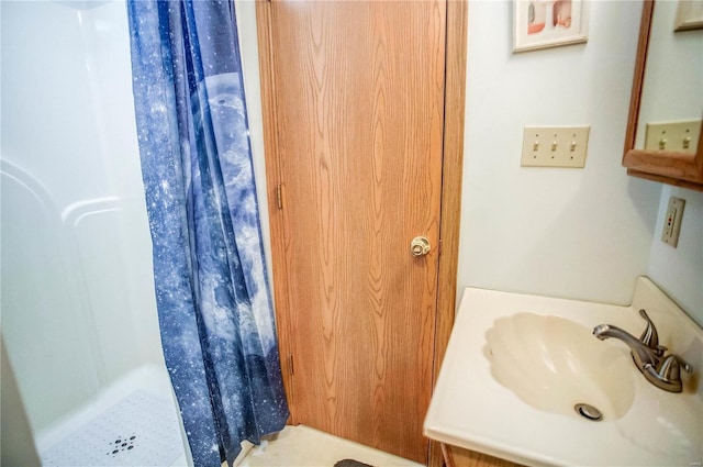 bathroom featuring a sink and a shower stall