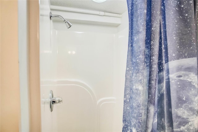 full bath with curtained shower and a textured ceiling