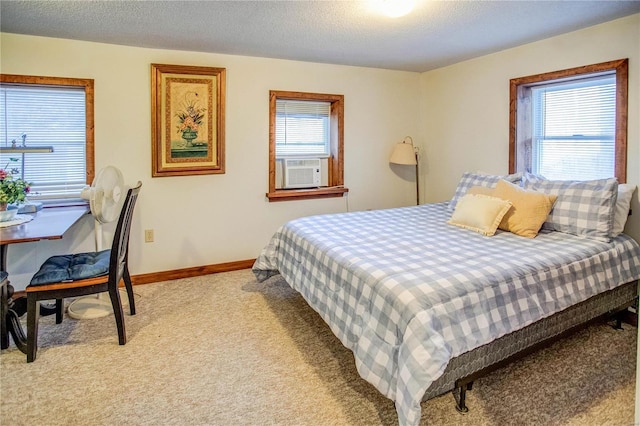 bedroom featuring light colored carpet, cooling unit, a textured ceiling, and baseboards