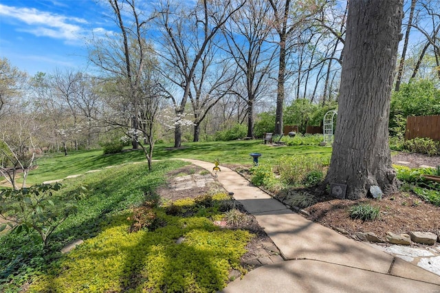 view of community featuring a yard and fence