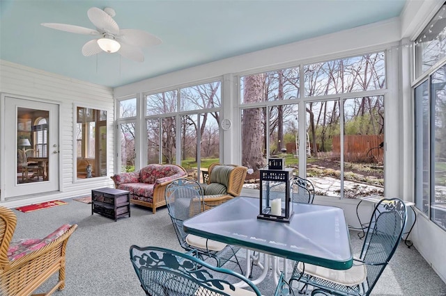 sunroom with outdoor lounge area, a ceiling fan, and carpet