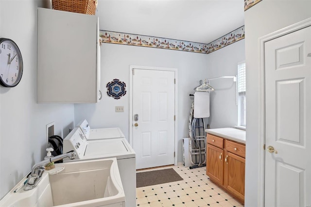 laundry room featuring light floors, washing machine and clothes dryer, cabinet space, and a sink