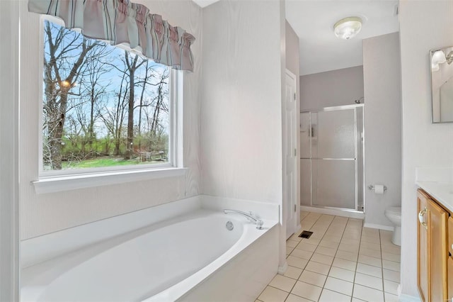 bathroom with toilet, tile patterned flooring, a shower stall, a garden tub, and vanity