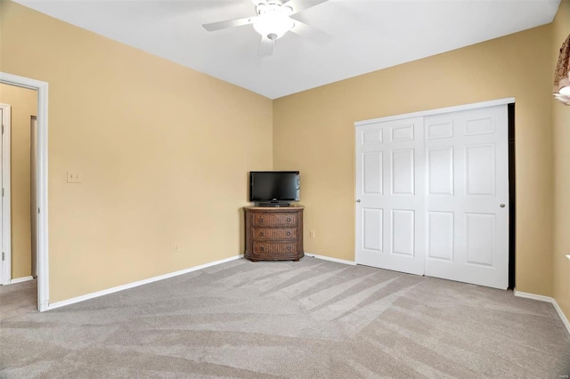 unfurnished bedroom with carpet floors, a closet, baseboards, and ceiling fan