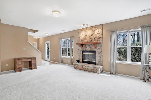 unfurnished living room featuring a fireplace, carpet floors, visible vents, and baseboards