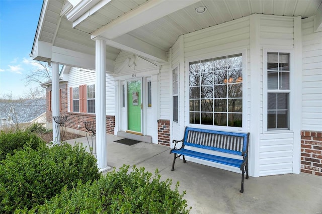 property entrance featuring brick siding and covered porch