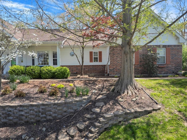 view of front facade featuring brick siding and a front lawn