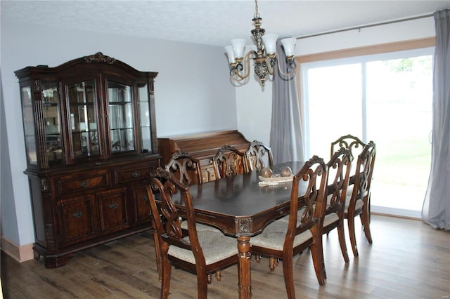 dining room with a chandelier, a textured ceiling, and wood finished floors