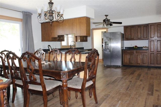 dining room with dark wood-type flooring and ceiling fan with notable chandelier