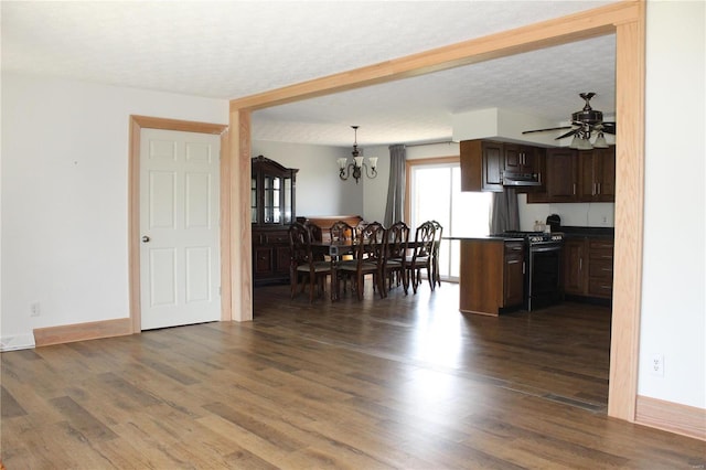 kitchen with dark wood-style floors, gas stove, a textured ceiling, and dark countertops