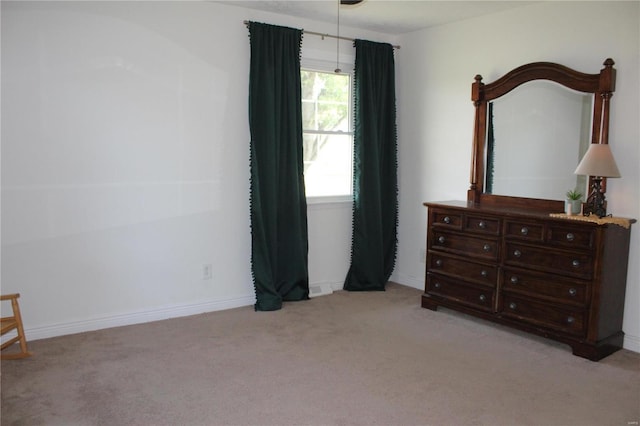 bedroom with light carpet and baseboards