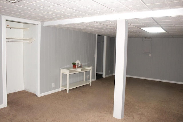 finished basement with carpet floors, electric panel, and baseboards