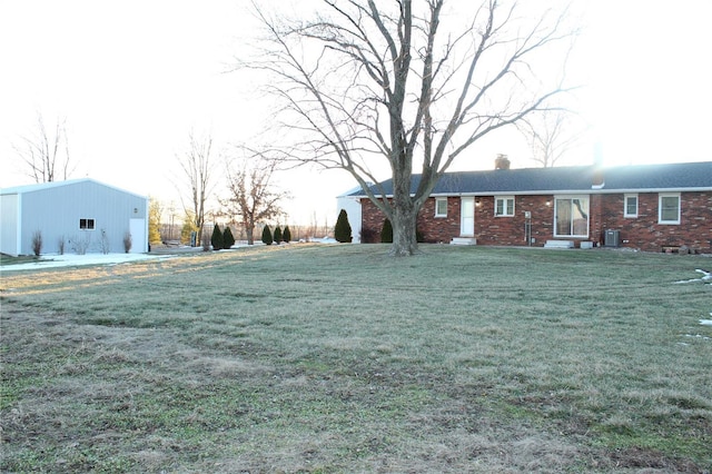 view of front of home with an outbuilding, brick siding, a chimney, and a front yard