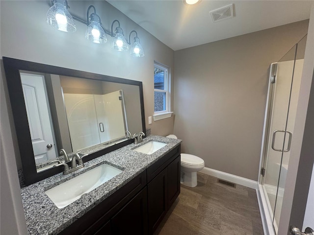 bathroom with a stall shower, a sink, and visible vents