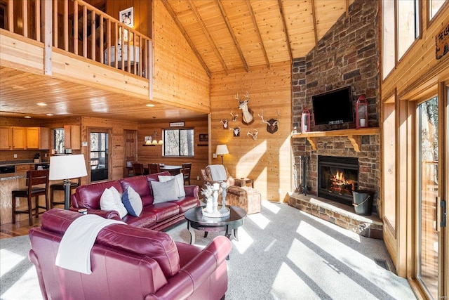 carpeted living room featuring vaulted ceiling, wooden ceiling, a fireplace, and wooden walls