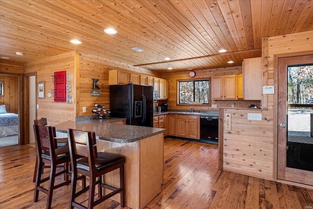 kitchen featuring a wealth of natural light, wooden ceiling, a peninsula, and black appliances