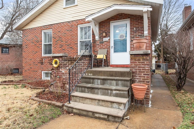 doorway to property featuring brick siding