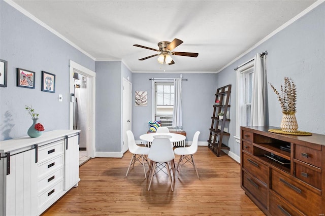 dining area with baseboards, light wood finished floors, and ornamental molding