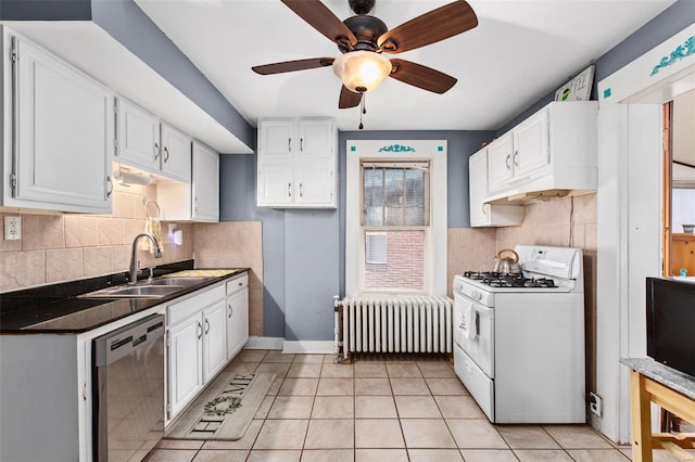 kitchen featuring radiator, white range with gas stovetop, a sink, dishwasher, and dark countertops