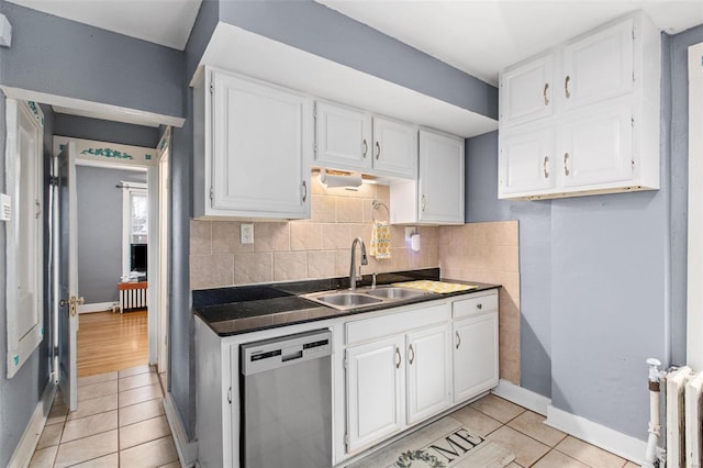 kitchen with radiator heating unit, decorative backsplash, white cabinets, stainless steel dishwasher, and dark countertops