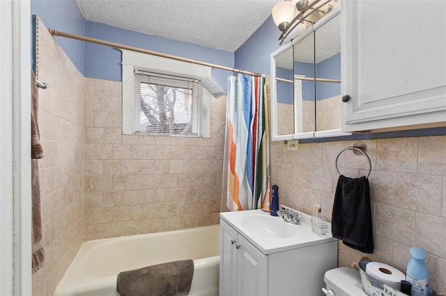 bathroom with shower / bathtub combination with curtain, toilet, a textured ceiling, tile walls, and vanity