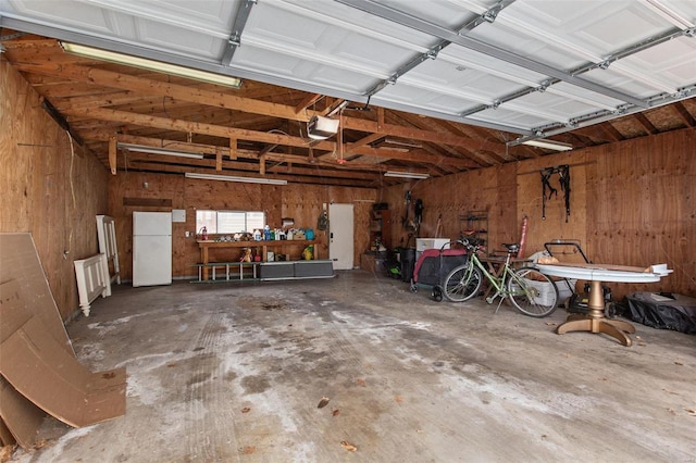 garage featuring a garage door opener and freestanding refrigerator