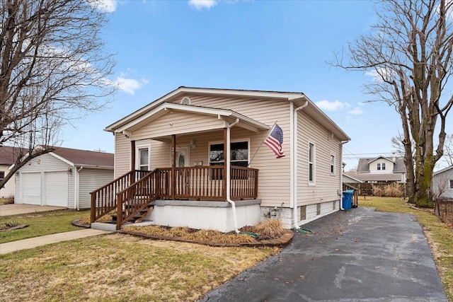 view of front facade featuring a garage, covered porch, an outdoor structure, and a front lawn