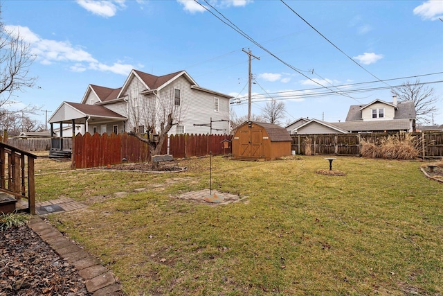 view of yard featuring a fenced backyard, a storage unit, and an outdoor structure