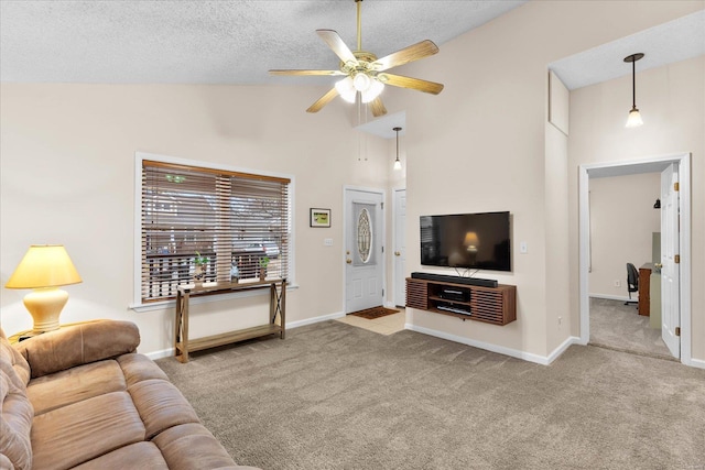 living room with a textured ceiling, carpet floors, ceiling fan, and baseboards