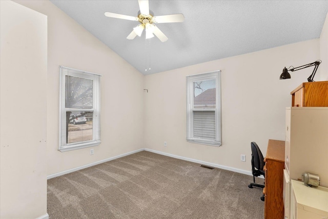 unfurnished office featuring lofted ceiling, ceiling fan, carpet flooring, and baseboards