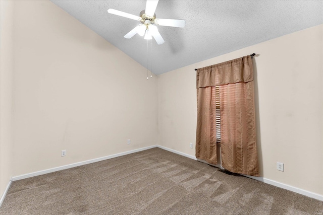 carpeted spare room with ceiling fan, baseboards, vaulted ceiling, and a textured ceiling