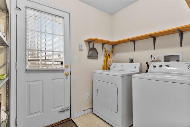 washroom featuring laundry area, light tile patterned flooring, and washing machine and clothes dryer