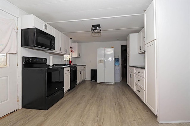 kitchen featuring dark countertops, black appliances, white cabinets, and light wood finished floors