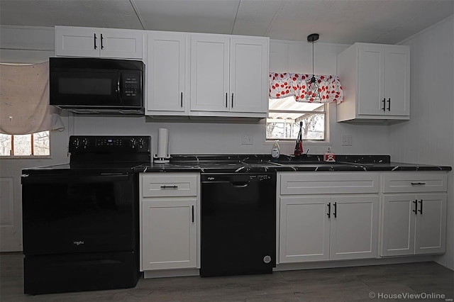 kitchen featuring black appliances, light wood-style floors, dark countertops, and white cabinets