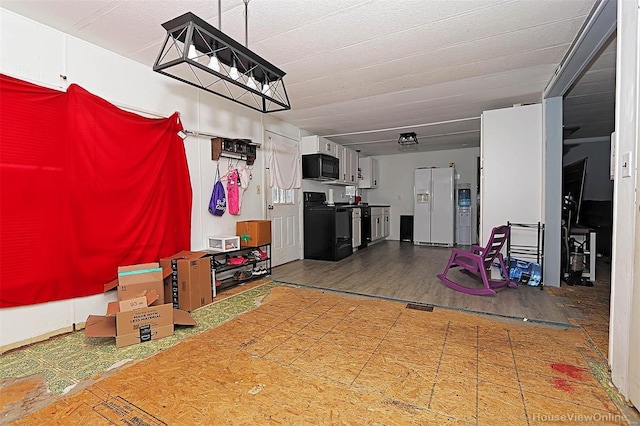 garage featuring white fridge with ice dispenser