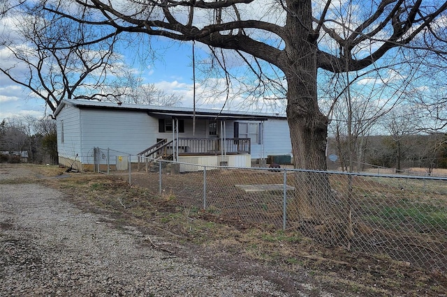 manufactured / mobile home with fence private yard and gravel driveway