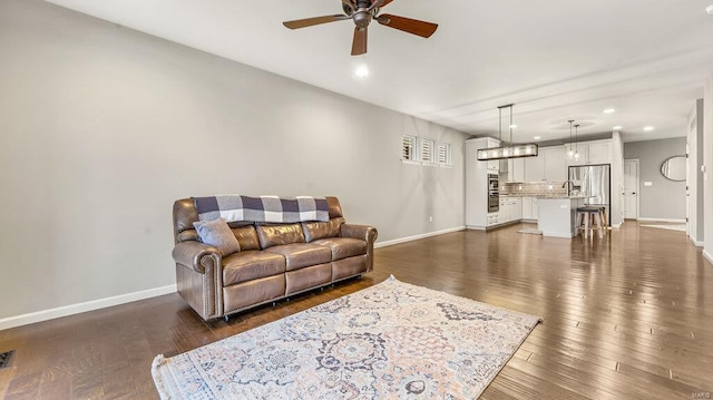 living area with dark wood finished floors, recessed lighting, ceiling fan, and baseboards