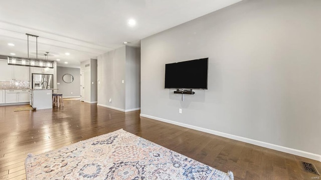 living room featuring dark wood-type flooring, recessed lighting, visible vents, and baseboards