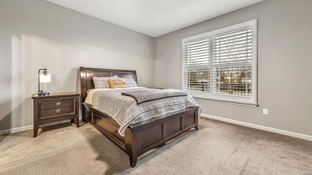 bedroom with baseboards and light carpet