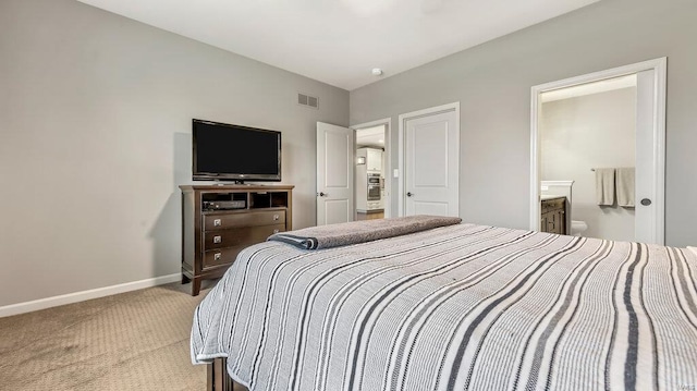 bedroom with connected bathroom, baseboards, visible vents, and light carpet