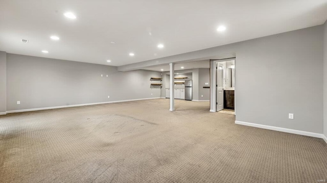 interior space featuring recessed lighting, light colored carpet, freestanding refrigerator, and baseboards