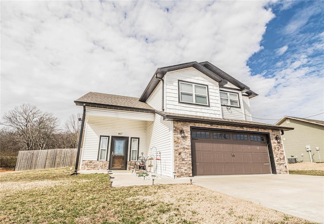 view of front of house with driveway, stone siding, an attached garage, fence, and a front yard