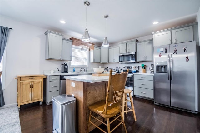 kitchen with light countertops, appliances with stainless steel finishes, dark wood-style flooring, and gray cabinetry