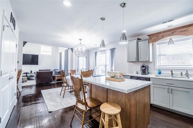 kitchen with open floor plan, light countertops, gray cabinets, and a center island