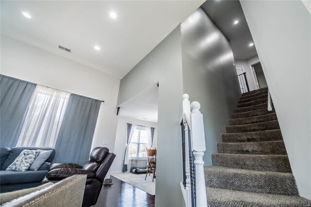 stairs featuring visible vents, wood finished floors, and recessed lighting