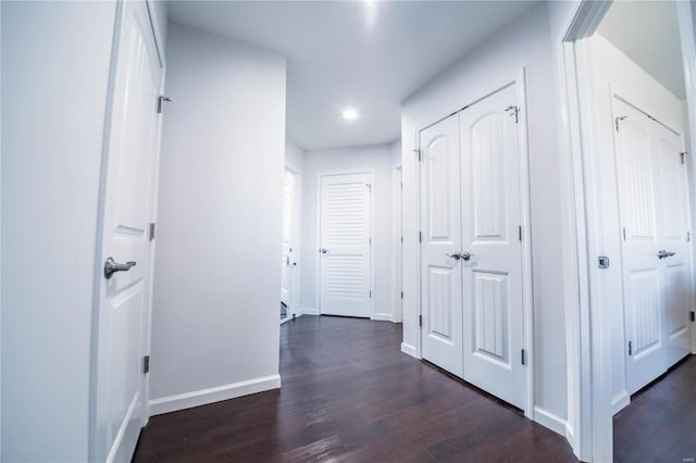 corridor with baseboards and dark wood-style flooring