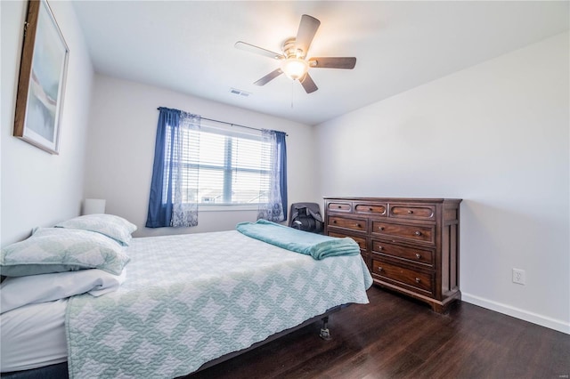 bedroom with visible vents, dark wood finished floors, a ceiling fan, and baseboards