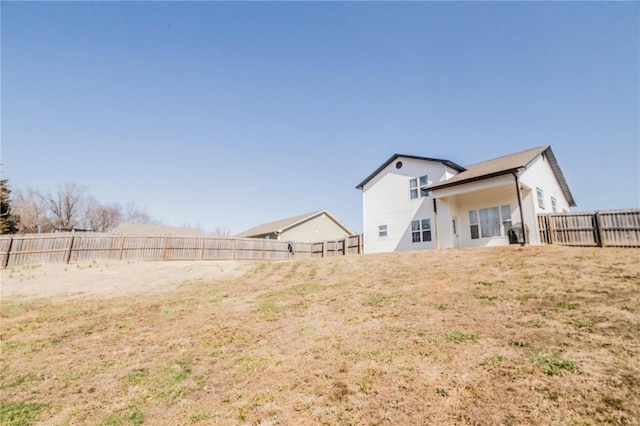 rear view of property featuring a fenced backyard