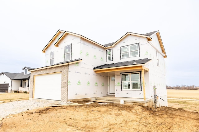 unfinished property with a garage and brick siding