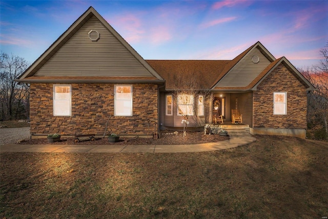 view of front facade with stone siding and a shingled roof